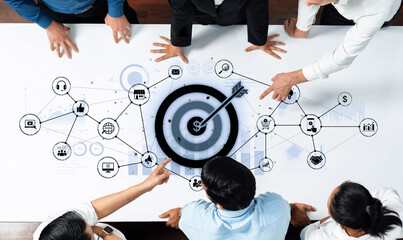 A dynamic business scene showcasing collaboration among professionals as they analyze digital connections and a target on a modern office table. Trope