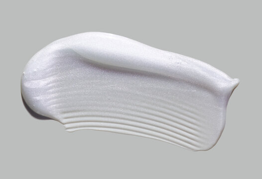 Cosmetic white silver luminous pearl shimmering lotion oil gel texture smudge on neutral grey background