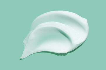 Face or body white cream hair balm or mask isolated on marine blue green background. Beauty product sample swatch