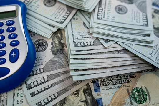 Office calculator on US currency symbolizing business finance, income management and profit analysis