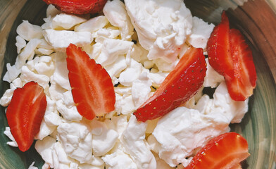 close-up of Homemade Cottage cheese with strawberries in a ceramic bowl on the marble table, top...