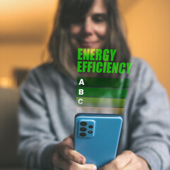 Smiling Woman Checking Energy Efficiency Ratings on a Smartphone, Focused on Sustainable Living and...