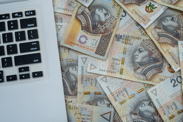 200 Polish zloty banknotes with laptop on desk, online banking and finance management, business technology