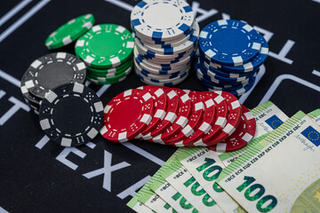 Stacks of euro banknotes and colorful poker chips symbolizing money, luck and casino gambling