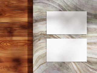 Clean business card layout on a marble surface and wooden backdrop for design showcase.
