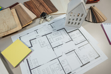 Wood laminate samples and interior plan on designer desk, home renovation and furniture concept