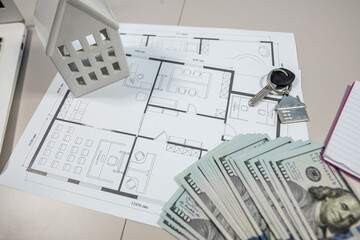 US dollar banknotes with house plan and wood texture samples on architect desk, renovation budget concept
