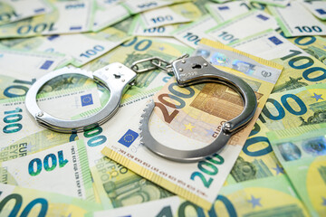 Handcuffs on 100 euro banknotes symbol of corruption and financial crime