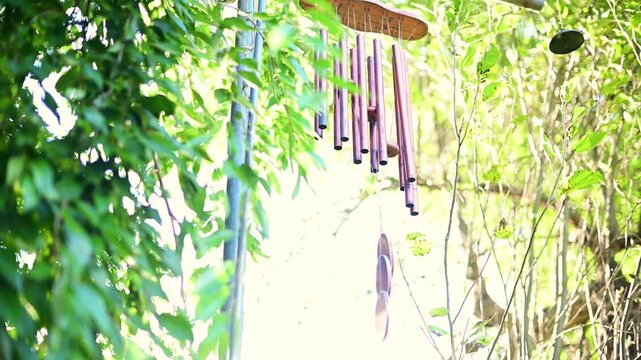 wind chimes selective focus overexposed video, cinematic scene,close up, leaves in the wind