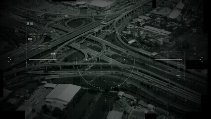 Aerial surveillance, military reconnaissance view of a complex highway interchange with HUD targeting graphics, creating a cinematic spy-drone atmosphere and intelligence-operation mood