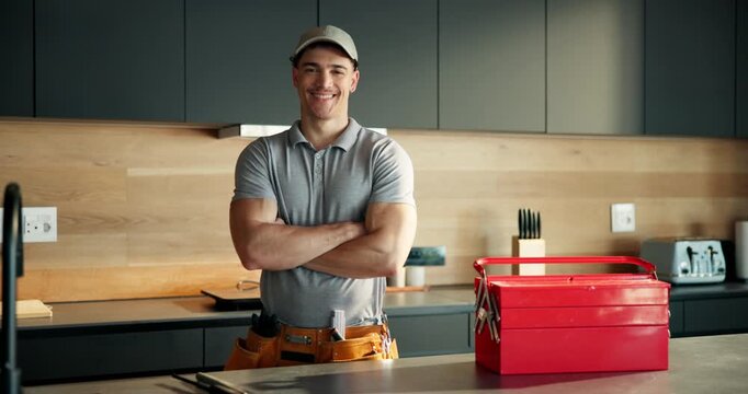 Arms crossed, plumber and face with man in kitchen for home improvement, pipe maintenance and leak detection. Water damage, handyman and inspection with person in house for labor and installation