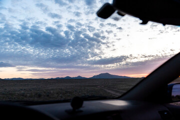 You can see a beautiful view of a sunset from inside a car