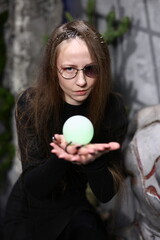 Young woman with glowing orb and ancient wall background