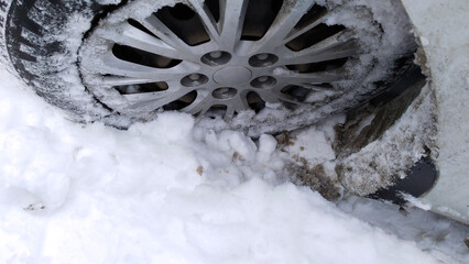 Car wheel on dirty messy snow. Mud, salt and chemicals on winter road. Protection and wash auto. Vehicle hubcap. Tire pressure. Tyre change. Transportation. Drive in severe icy weather. Driving. maint