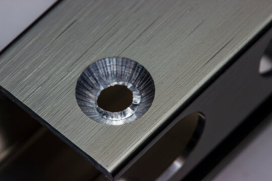 a countersunk milled hole in an aluminum facade profile in close-up. a macro photo of the production process. an illustration.