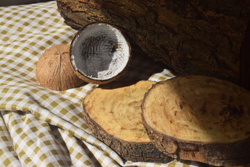 Cenário rústico para exposição de produtos feitos do coco com cepos de madeira e tronco de árvore