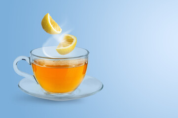 Citrus drink for health boosting. Lemon pieces falling into cup on light blue background. Cold season remedy