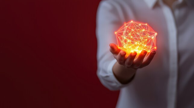 A hand holds a glowing polygon made of interconnected lines, symbolizing innovation and technology against a red background.