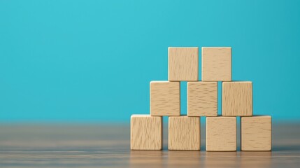 A stack of wooden blocks arranged in a triangular pattern against a blue background, showcasing simplicity and creativity in design.