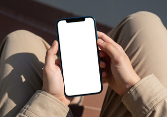 Hands holding a modern smartphone with blank white screen for mockup