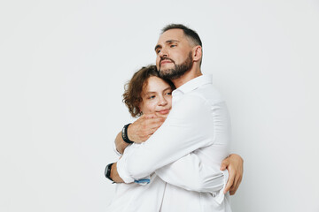 A professional man embraces a colleague in a warm hug against a plain white background, conveying trust, calm confidence, and a supportive business atmosphere.