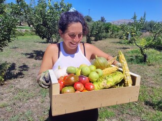 Happy Woman Harvesting Fresh Organic Vegetables in a Sunny Orchard