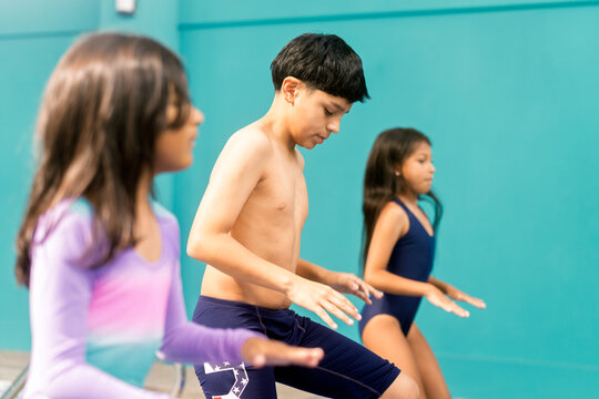 Children doing warm up exercises for swimming lessons