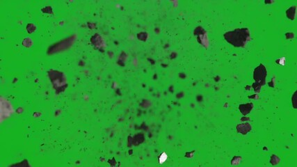 Explosive rock and debris fragments flying towards camera on a green screen background for visual effects.