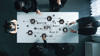A professional business team collaborates at a meeting, analyzing key performance indicators and strategic goals with visual data on a conference table to drive success. Amity
