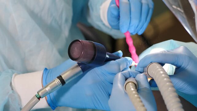 Professional dental teeth cleaning in modern dental clinic. closeup shot. Real footage of woman getting teeth treatment by professional dentists. Dental care concept. Getting rid of plaque and