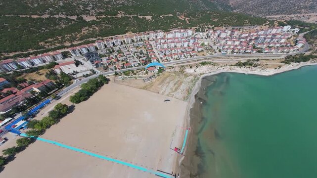 An exhilarating footage of a parachutist gliding gracefully under the bright midday sun, capturing the thrill of adventure and the beauty of the surrounding landscape,oe01