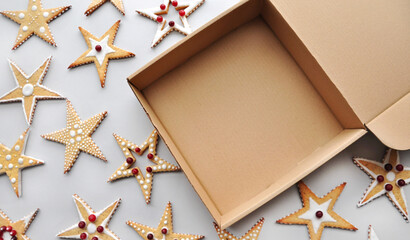Christmas cookie packaging. Star-shaped cookies decorated with icing and berries. Cardboard box, opened. Sustainable gift packaging