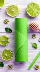 A bright green cylindrical object is centrally placed amidst a refreshing arrangement of sliced limes, kiwi rounds, and mint leaves.