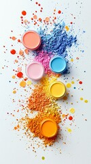 A collection of small containers filled with vibrant powdered paints, artfully arranged with scattered droplets of paint on a white background.