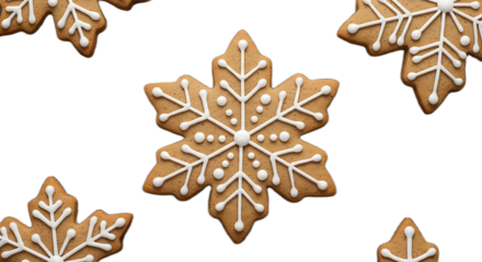 Close up of snowflake shaped gingerbread cookies decorated with white icing on black background