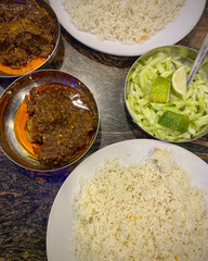 A topdown view of a delicious indian meal with rice and curry served in traditional bowls
