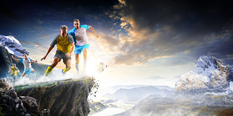 Soccer players in action high in the mountains on the edge of a cliff. Sports concept. Extreme...