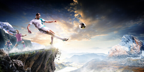 Soccer players in action high in the mountains on the edge of a cliff. Sports concept. Extreme sports moment. Panorama. Cliff. Football players.