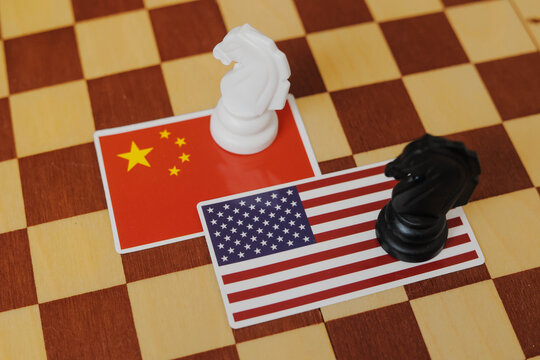 Chinese flag and a Flag of USA on chessboard. Tariffs war and conflict between those two countries.