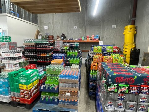 Grocery store interior pallets of various drinks in a warehouse