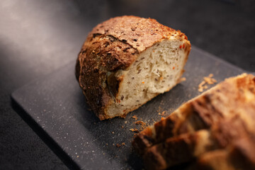 Close-up of sliced gluten free bread on black board.