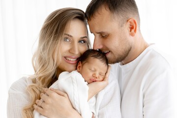 Happy Parents Holding Newborn Baby. Family Love and Care. Mother, Father and Child Portrait