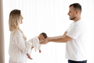 Loving Parents Cradling Newborn Baby in Hands. Tender Moment of Family Bonding and Care.