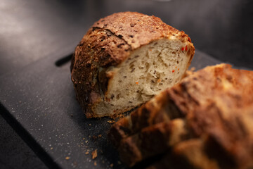 Close-up of sliced gluten free bread on black board.