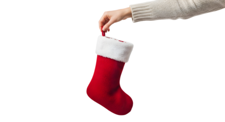 Human hand holding a red Christmas stocking with white fur trim, isolated on a white background, cozy holiday theme.