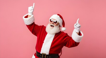 Joyful santa claus in sunglasses dancing and pointing upwards with both hands on a pink background