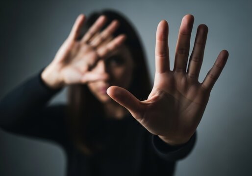 Woman holding up her hand in a gesture to stop, symbolizing consent, boundaries, and saying no to unwanted advances or harassment