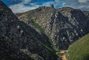 Dramatic mountain landscape with rugged peaks and a cloudy sky above