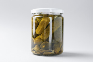 Pickled cucumbers in jar on light background, closeup