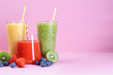 Different tasty smoothies in glasses and ingredients on pink background, closeup